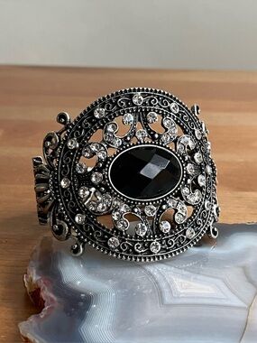 Vintage-style hinged cuff bracelet featuring a large black center stone jewelry